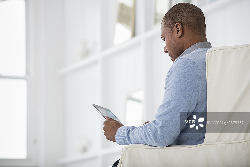 城市里明亮通风的商务办公场所，男人使用平板电脑图片素材