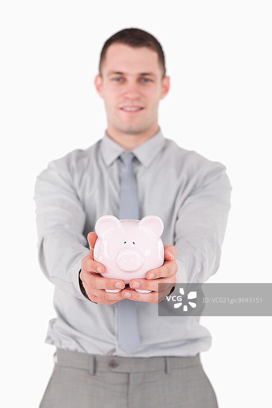 年轻商人手持存钱罐图片素材