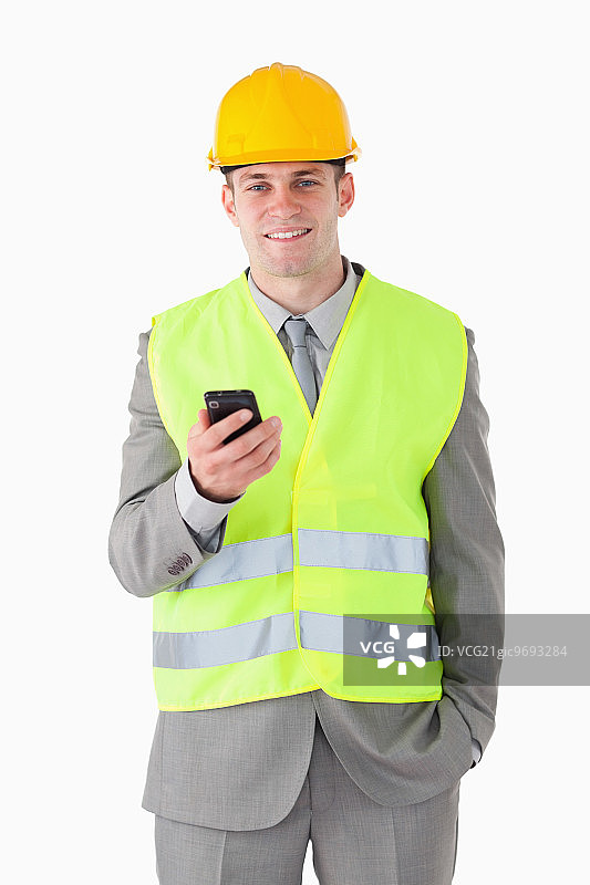 白色背景下手持手机的年轻建筑工人肖像图片素材