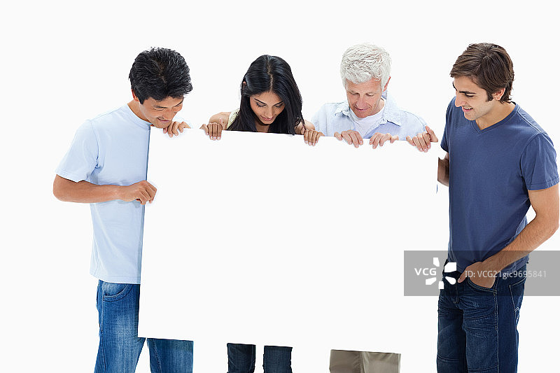 穿牛仔裤的人拿着并观看白色背景上的大标志图片素材