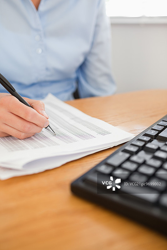 在办公室里用笔划数字的女商人图片素材