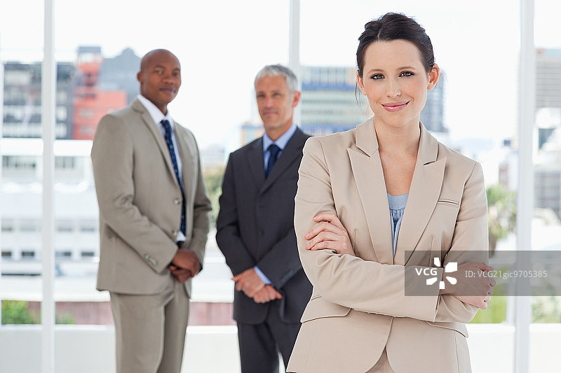 年轻微笑的女秘书在两位主管面前交叉双臂图片素材