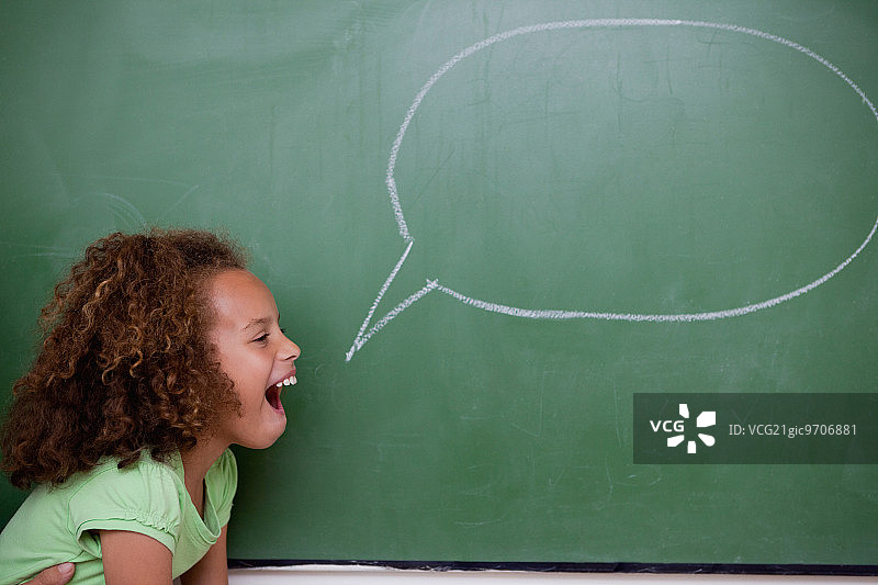 在教室里拿着对话气泡的女学生图片素材