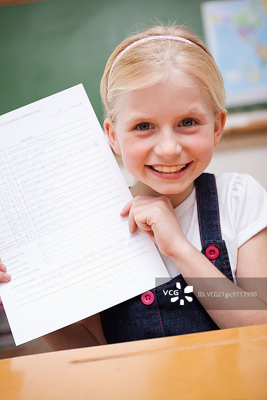 在教室里展示成绩单的快乐女孩图片素材