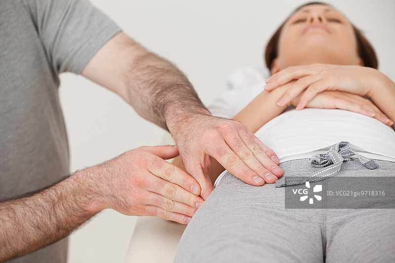 理疗师在房间里按摩女人大腿图片素材