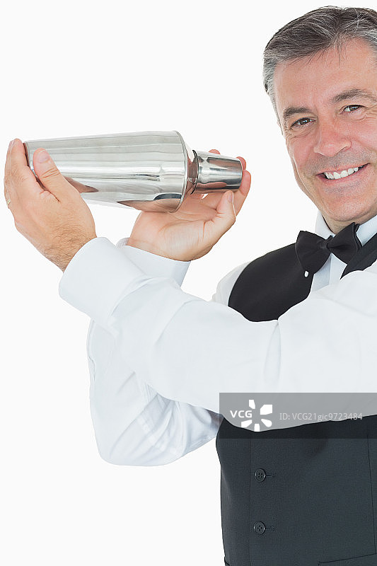 微笑的酒吧调酒师调制鸡尾酒图片素材