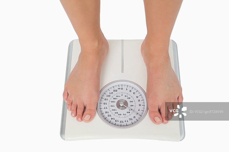 女人双脚站在白色体重秤上图片素材