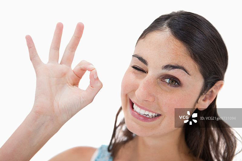 在白色背景下做出一切都很好手势的嬉戏女人图片素材