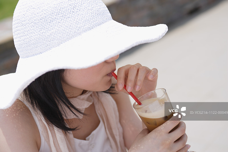 戴帽子的女人在喝东西图片素材