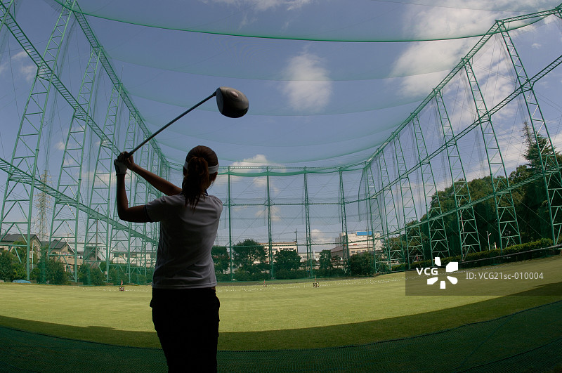 女人在高尔夫球场打高尔夫球图片素材