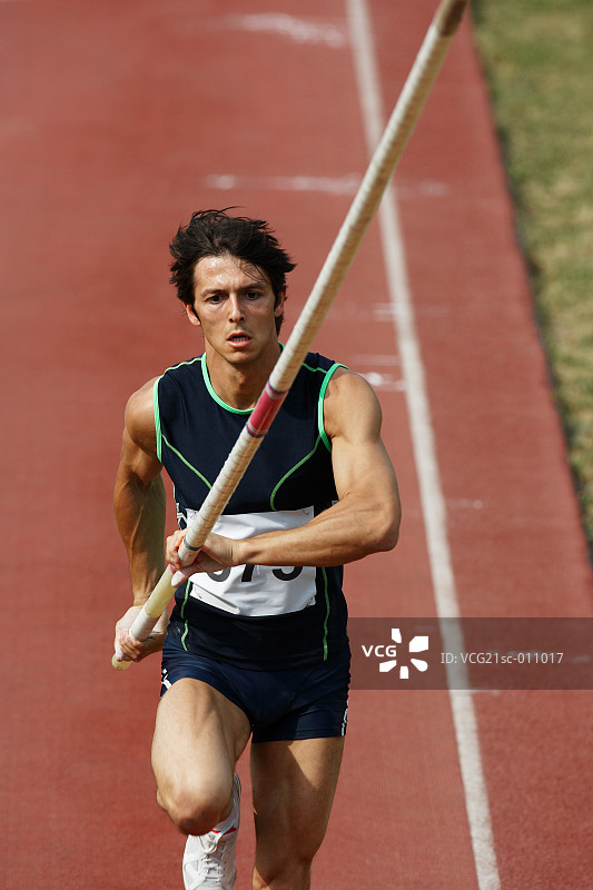 男性撑杆跳运动员在赛道上冲刺图片素材