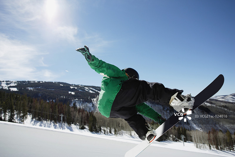 单板滑雪者在半管滑道上滑行图片素材