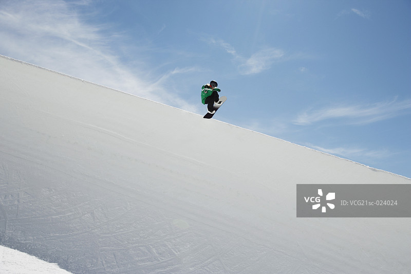 单板滑雪者在半管滑道上滑行图片素材