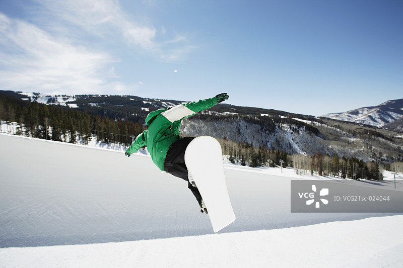 单板滑雪者在半管滑道上滑行图片素材