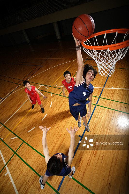 年轻的亚洲篮球运动员扣篮图片素材