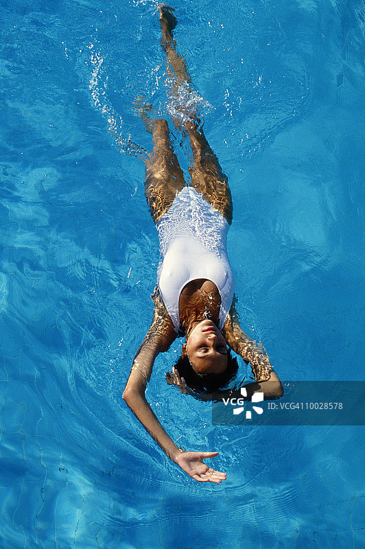 女人在游泳池里仰泳图片素材