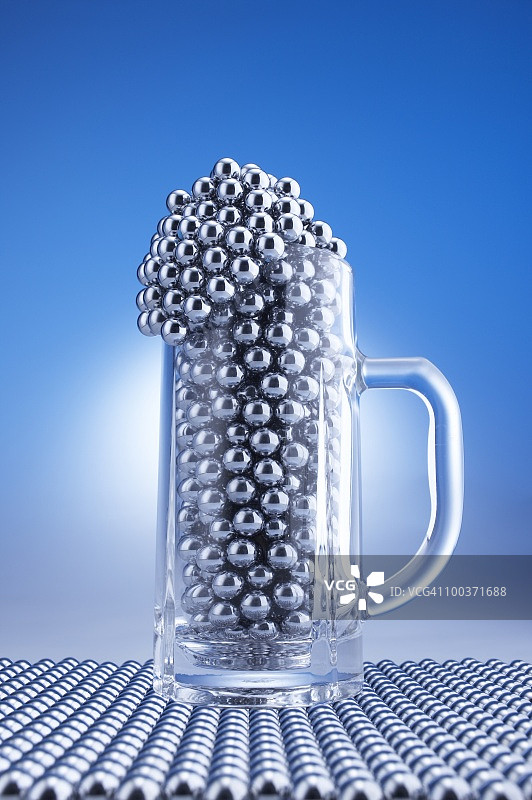 装满柏青哥球的啤酒杯，电脑图形，蓝色背景图片素材