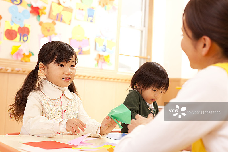幼儿园老师教孩子们折纸图片素材