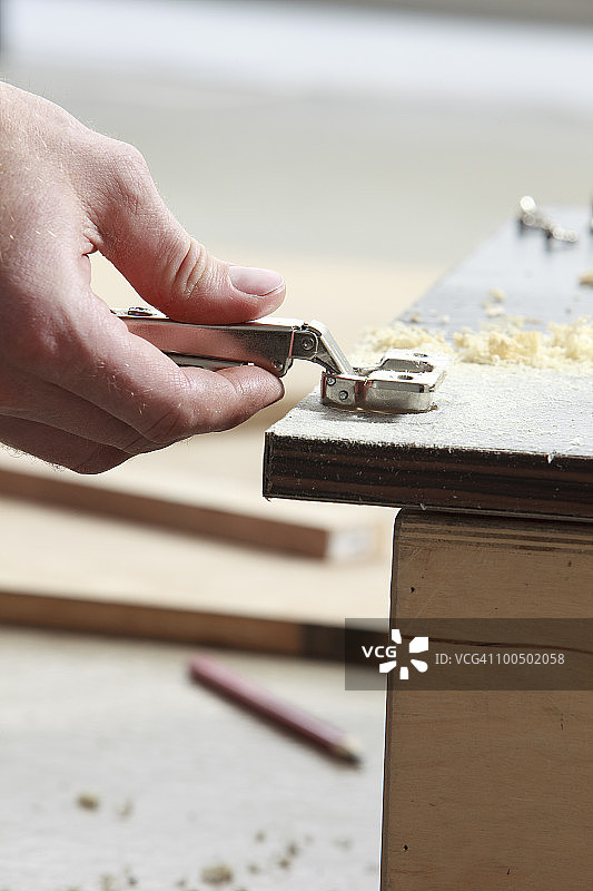 男人在门上安装合页图片素材