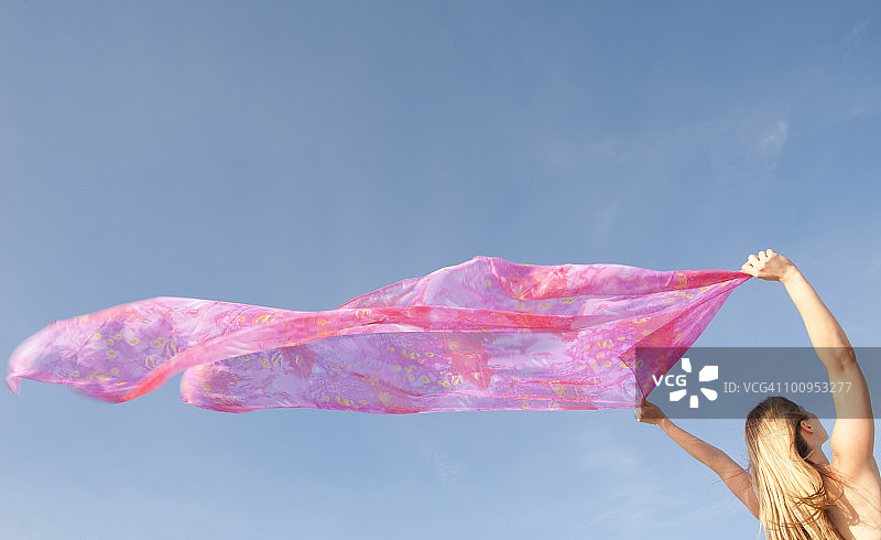 女人在风中拿着粉色纱笼图片素材