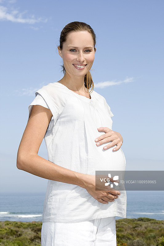 海边的年轻孕妇肖像图片素材