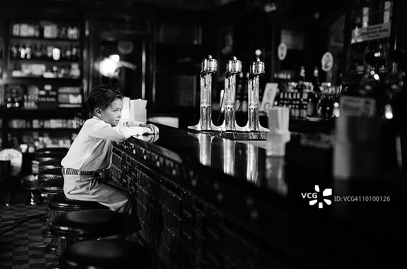 独自坐在苏打水机旁的男孩图片素材