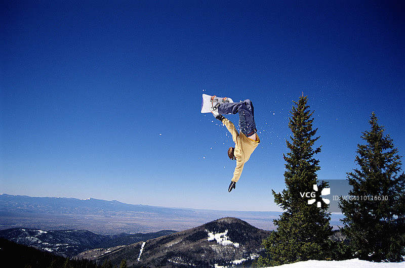 在圣菲跳跃的男性单板滑雪者，新墨西哥州图片素材