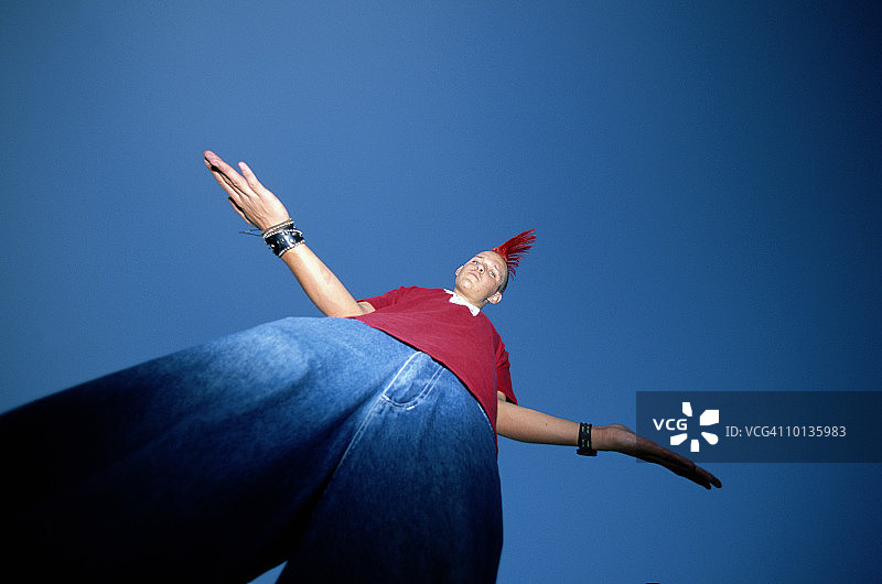 留着莫霍克发型、张开双臂的X世代年轻男人图片素材