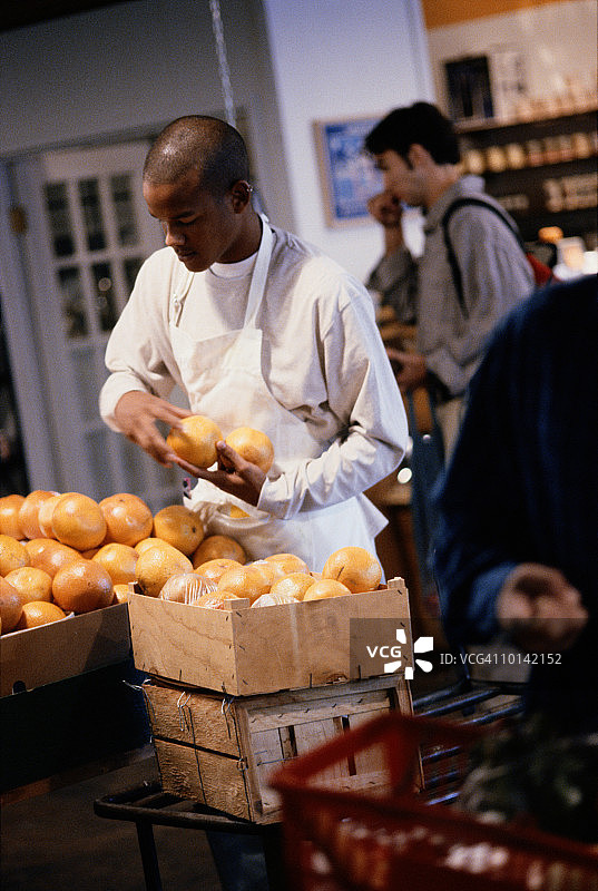 在杂货店工作的年轻黑人男子图片素材