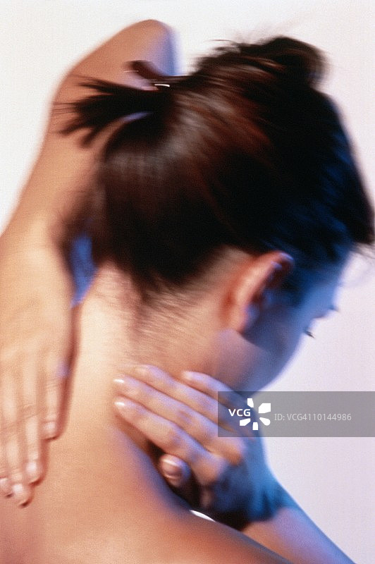 年轻女子按摩背部，缓解疼痛图片素材