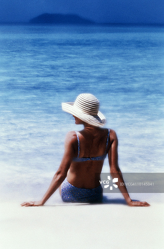 女子坐在沙滩上，圣约翰，美国维尔京群岛后视图图片素材