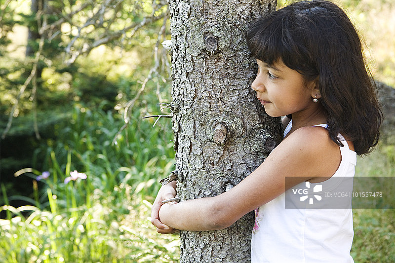 拥抱树的年轻女孩图片素材
