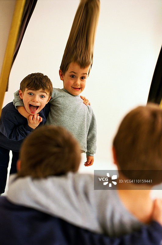 年轻男孩看着哈哈镜图片素材