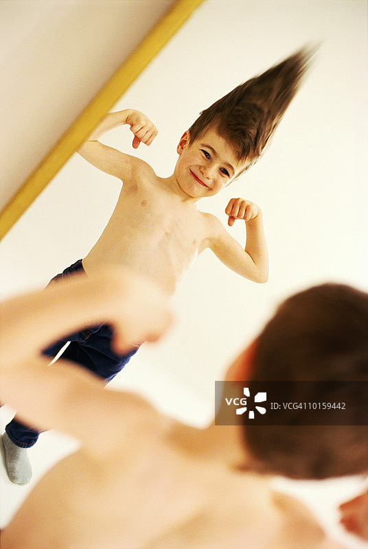 年轻男孩看着哈哈镜图片素材