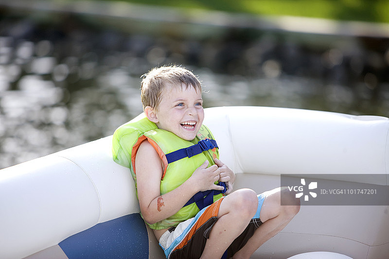 坐在船上笑的小男孩图片素材