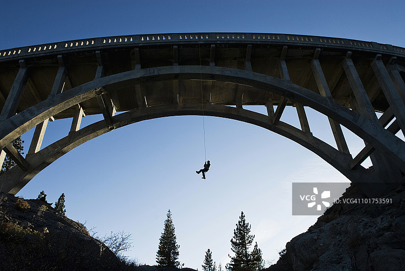 年轻男人在加州特拉基唐纳山口大桥攀岩图片素材