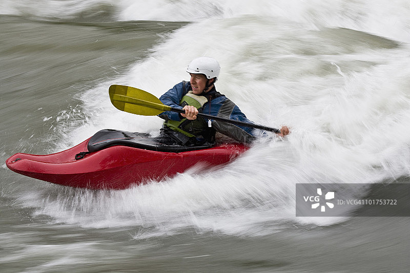 年轻男子在加拿大不列颠哥伦比亚省的埃尔克河上玩皮划艇冲浪图片素材