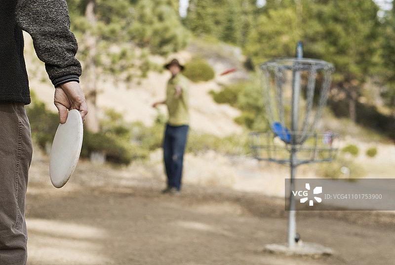 在加利福尼亚州太浩湖打飞盘高尔夫比赛前，一位年轻人正在练习图片素材