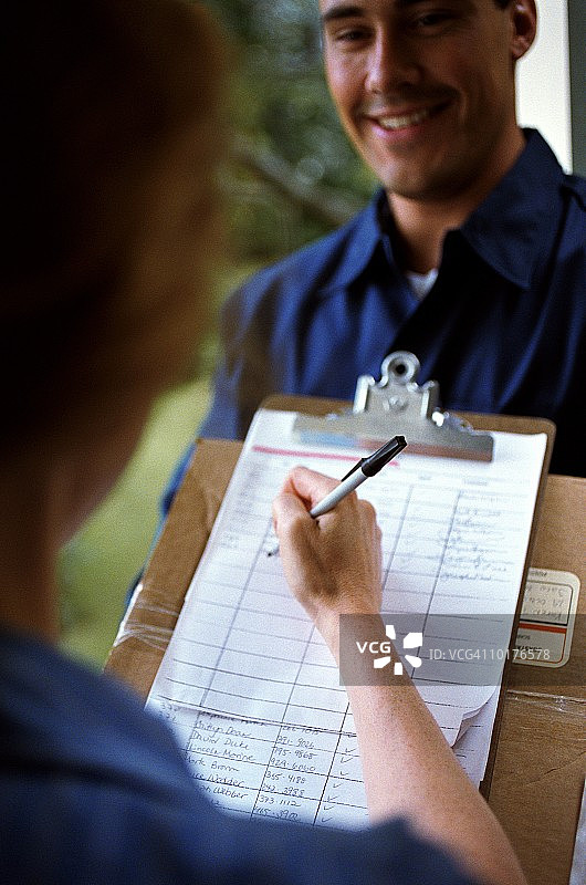 女子和男子在交接快递时签收图片素材