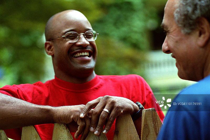 两位邻居在栅栏旁交谈图片素材