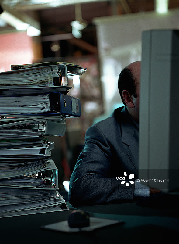办公室里堆满文件夹的男人图片素材