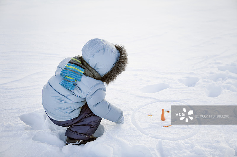 男孩在雪地里玩耍图片素材