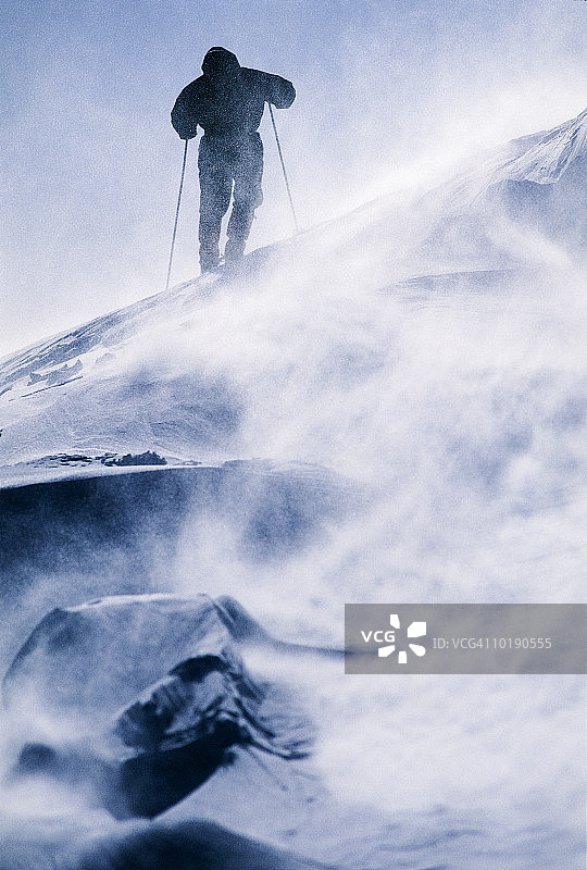 男子在暴风雪中徒步（后视图）图片素材