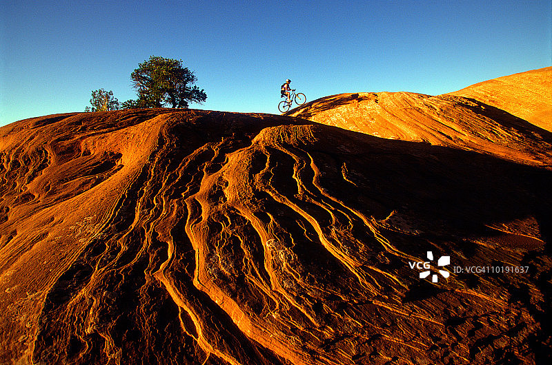 女自行车手穿越岩石图片素材
