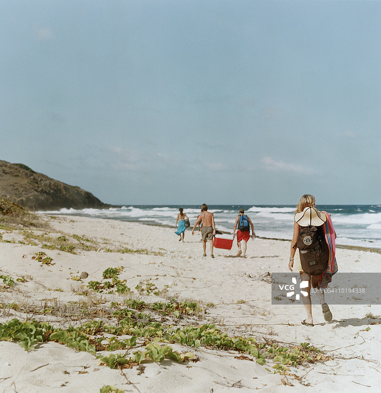 一群人在海滩上行走，后视图图片素材