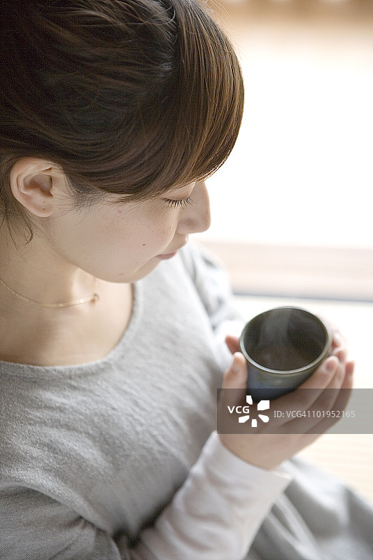 年轻女子拿着一杯绿茶图片素材