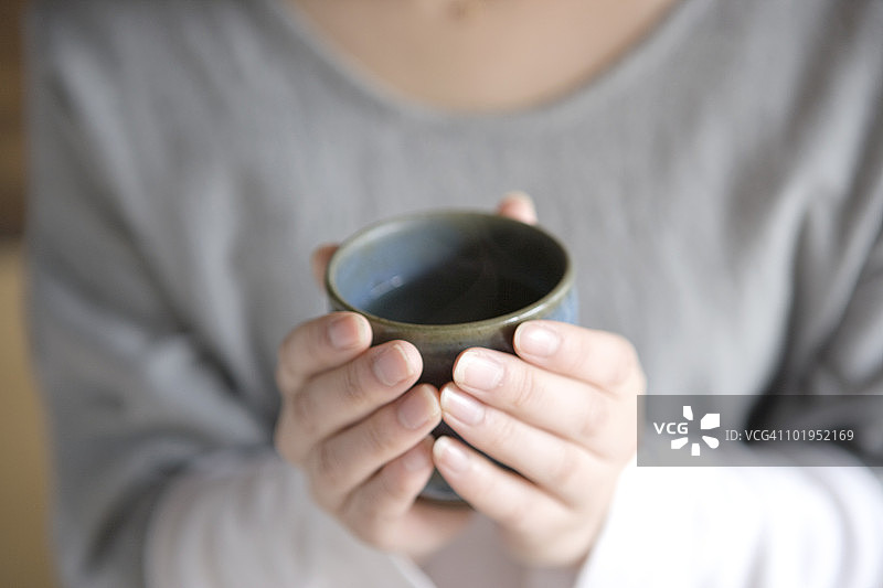 年轻女子拿着一杯绿茶图片素材