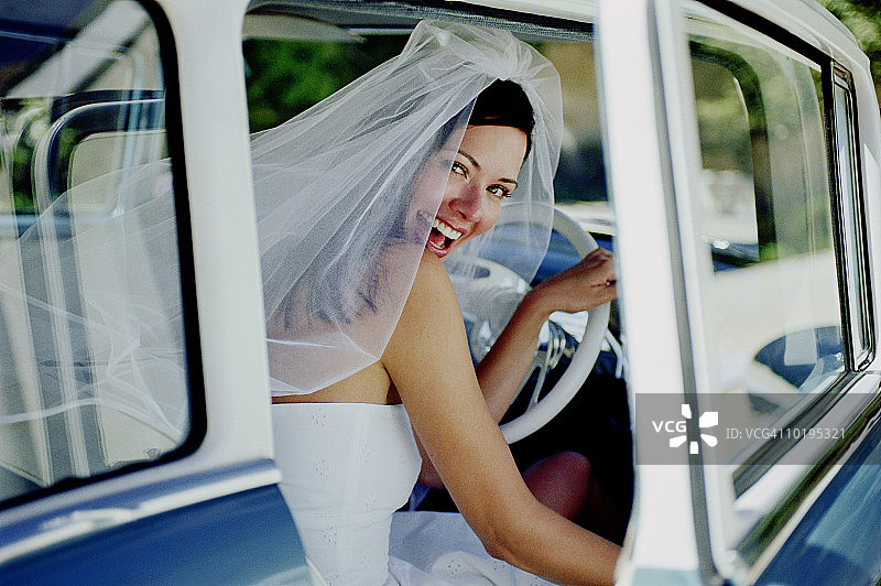 坐在汽车驾驶座上的新娘，肖像图片素材