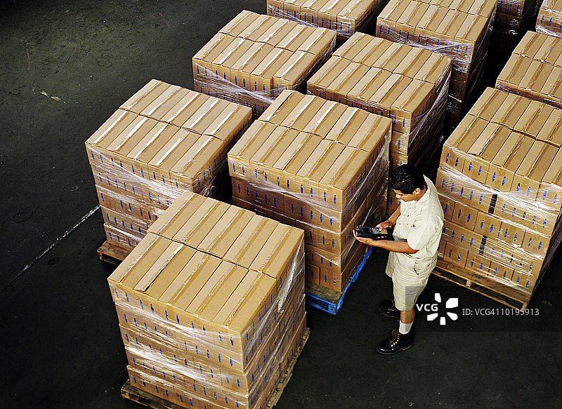 男人在仓库中手持库存跟踪设备图片素材