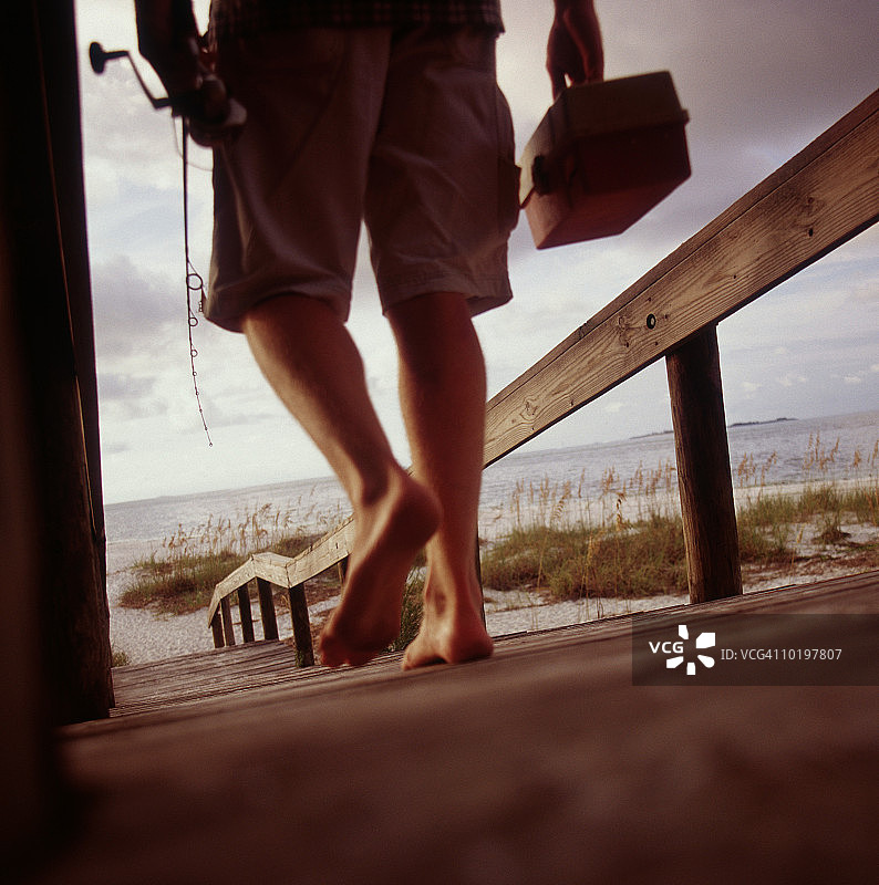 走向海滩的钓鱼者（低角度）图片素材